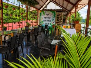 an empty restaurant with tables and chairs and plants at Fanda in Sauce
