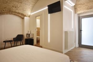a bedroom with a bed and a tv on the wall at B&B Ago e Luce - YourPlace Abruzzo in Vasto