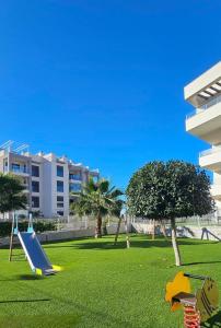 a playground with a slide in a park at Private Garden Apartment - Villamartin, Orihuela Costa in Villamartin