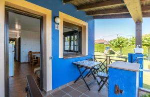 a room with a blue wall and a table on a balcony at Complejo rural Alhelí - Apartamentos y habitaciones in Valdredo
