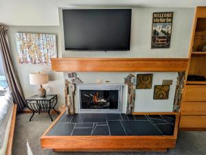a living room with a fireplace with a flat screen tv above it at Lakeside 1485 by SummitCove Lodging in Colorado in Keystone