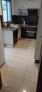 a kitchen with a white tiled floor at Ville n4 in Sidi Daoud