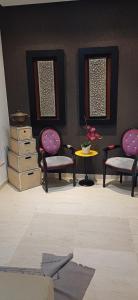 a living room with chairs and a table and a table at Ville n4 in Sidi Daoud