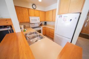 a kitchen with a white refrigerator and a sink at Lakeside 1495 by SummitCove Lodging in Colorado in Keystone