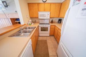 a kitchen with a sink and a stove and a microwave at Lakeside 1495 by SummitCove Lodging in Colorado in Keystone +33 photos