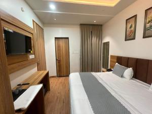 a hotel room with a bed and a flat screen tv at Hotel jbs inn in Jaipur
