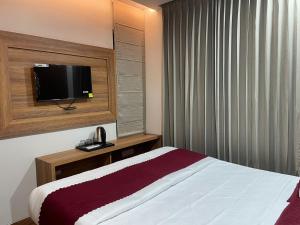 a hotel room with a bed and a flat screen tv at Hotel jbs inn in Jaipur