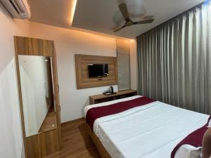 a hotel room with a bed and a television at Hotel jbs inn in Jaipur +1 photo