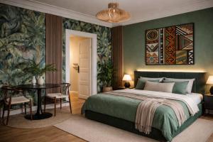 a bedroom with a bed and a table and a painting at Greenbrook Homes - Jungle Suite in Aalborg