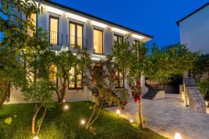 a house with lights in the yard at Le Mom Apart Hotel in Berat