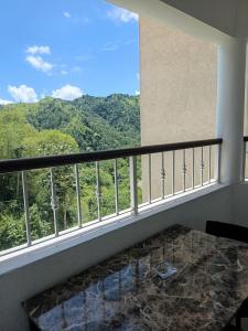 a balcony with a table and a view of the mountains at Gorgeous One Bedroom Apartment in Kingston