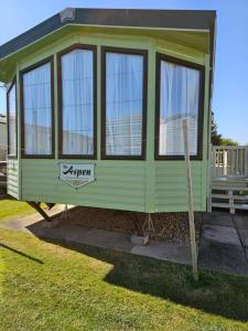 a green tiny house on display in a yard at Bella in Skegness