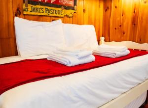 a bed with white pillows and towels on it at Cottage 1-2 -2 Bedroom 1 Bath End Unit with Kitchenette Private Courtyard Pet Friendly fee applies in Wolfeboro