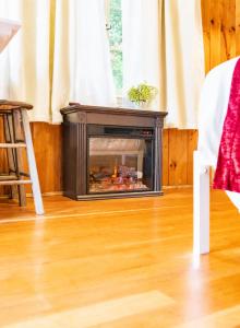a fireplace in a living room with a wooden floor at Cottage 1-2 -2 Bedroom 1 Bath End Unit with Kitchenette Private Courtyard Pet Friendly fee applies in Wolfeboro