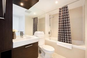 a bathroom with a sink and a toilet and a shower at Altitude Suites on Yonge - Downtown Toronto Short Walk to SickKids, TMU & Eaton Centre in Toronto