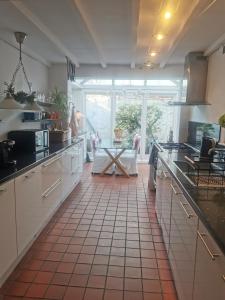 a kitchen with white cabinets and a tile floor at Lavender Cottage in Yarm
