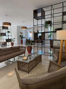 a living room with couches and tables and potted plants at Hotel Roma in São Sebastião +55 photos