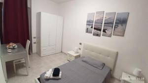 a small bedroom with a bed and a desk at Mare e Città in Selargius