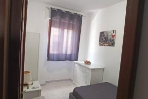 a small bedroom with a dresser and a window at Mare e Città in Selargius