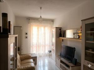a living room with a couch and a television at Mare e Città in Selargius