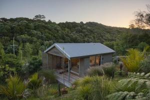 a small house in the middle of a forest at One O One Cabins, Waiheke Island in Oneroa