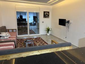 a living room with a couch and a tv at Appartement vue mer 200m in Rejiche