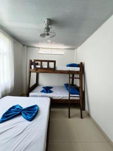 two bunk beds in a small room with blue bows at Hotel villa dulce campestre in Melgar +22 photos