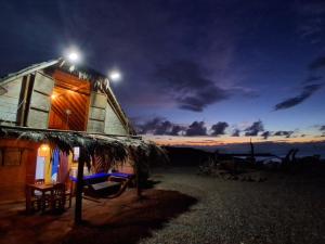 a house with a hammock outside of it at night at La Casa del Naufrago in Lobitos