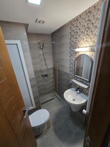 a bathroom with a sink and a toilet and a mirror at Appartement Iris in Gabès
