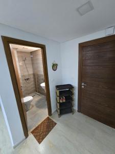 a bathroom with a shower and a toilet and a door at Appartement Iris in Gabès