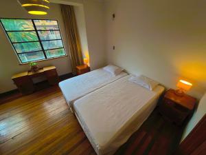 a bedroom with a white bed and a window at Hostel Hotzenplotz Alegre in Valparaíso