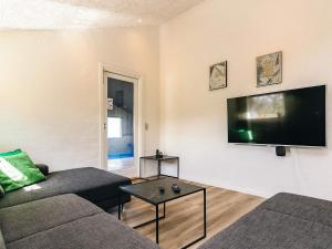a living room with a couch and a flat screen tv at 4 star holiday home in Vinderup in Vinderup