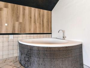 a bath tub in a bathroom with a wooden wall at 4 star holiday home in Vinderup in Vinderup +31 photos