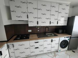 a kitchen with white cabinets with black writing on it at Cubo Rooms Olhão in Olhão +13 photos