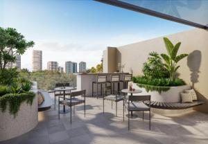 a rooftop patio with tables and chairs and a city skyline at The Sebel Parramatta in Sydney