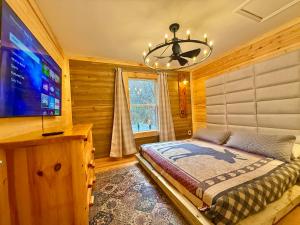 a bedroom with a bed and a flat screen tv at Charming vacation nest in Sevierville