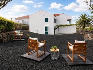 a patio with two chairs and a house at Inn Fraga in Ribeirinha
