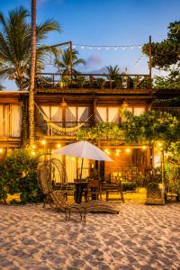 a table with an umbrella in front of a building at Luma by Zakua in Guachaca