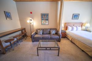 a hotel room with a bed and a couch and a table at Gateway Lodge 5054 by SummitCove Lodging in Colorado in Keystone +27 photos