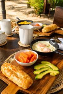 a wooden table topped with bowls of food and vegetables at Luma by Zakua in Guachaca +34 photos