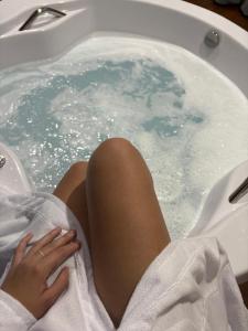 a woman laying in a jacuzzi tub at Chalés Mirante da Colina in Venda Nova do Imigrante
