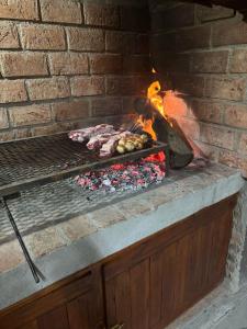 a brick oven with meat and vegetables in it at Complejo Renacer in Villa Parque Siquiman