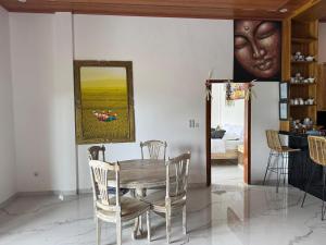 a dining room with a table and a giant head on the wall at Villa Bagus in Lovina