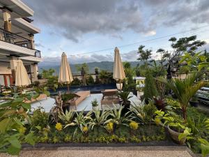 a patio with umbrellas and plants in a resort at Villa Bagus in Lovina