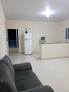a living room with a couch and a refrigerator at Chácara Mirante das Colinas in Atibaia