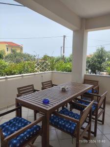 a wooden table and chairs on a balcony at Villa Galazia in Megalochori