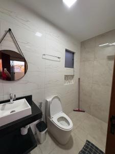 a bathroom with a toilet and a sink and a mirror at Pousada Nascer da Lua in São Thomé das Letras +47 photos