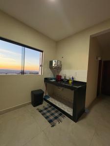 a room with a counter and a large window at Pousada Nascer da Lua in São Thomé das Letras