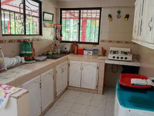 a kitchen with white cabinets and stained glass windows at Cabaña Villa Gabi in San Antero