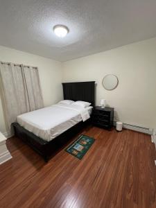 a bedroom with a bed and a wooden floor at Spacious 3BR Niagara Stay + Backyard in Niagara Falls